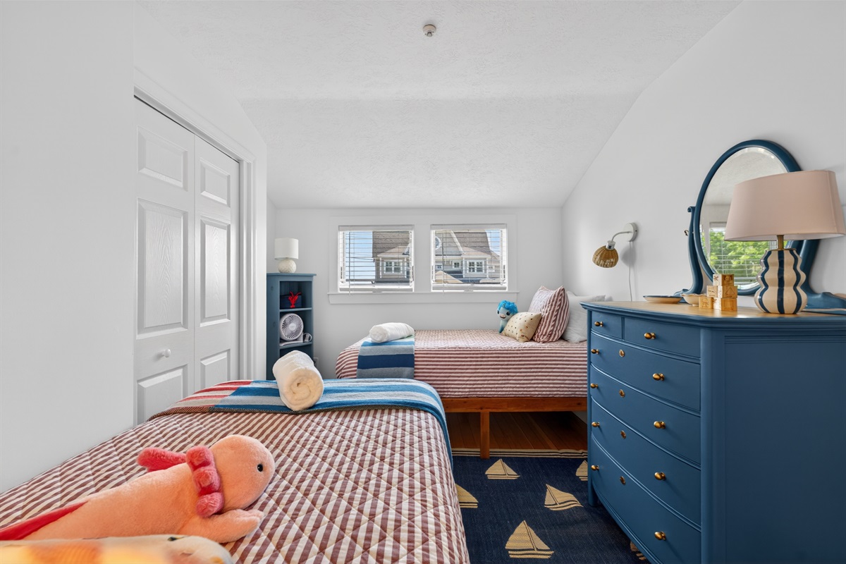 Cheerful twin bedroom with two beds and cozy coastal touches, ideal for kids or extra guests.