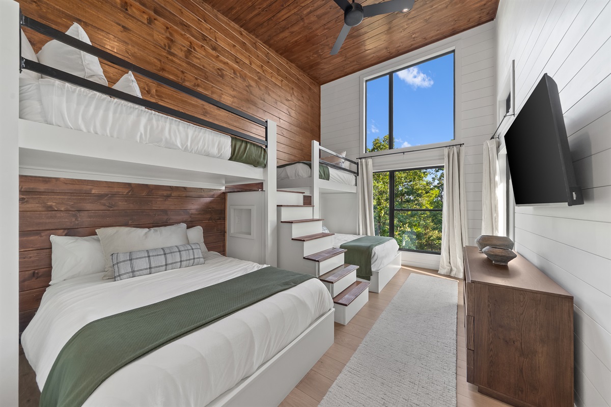 Bunk room with 2 bunk-bed units: 2 single/twin mattresses on top and 2 queen mattresses on the bottom (4 beds total). Sleeps 6. Cedar wood finishes, smart TV, and luxurious linens.