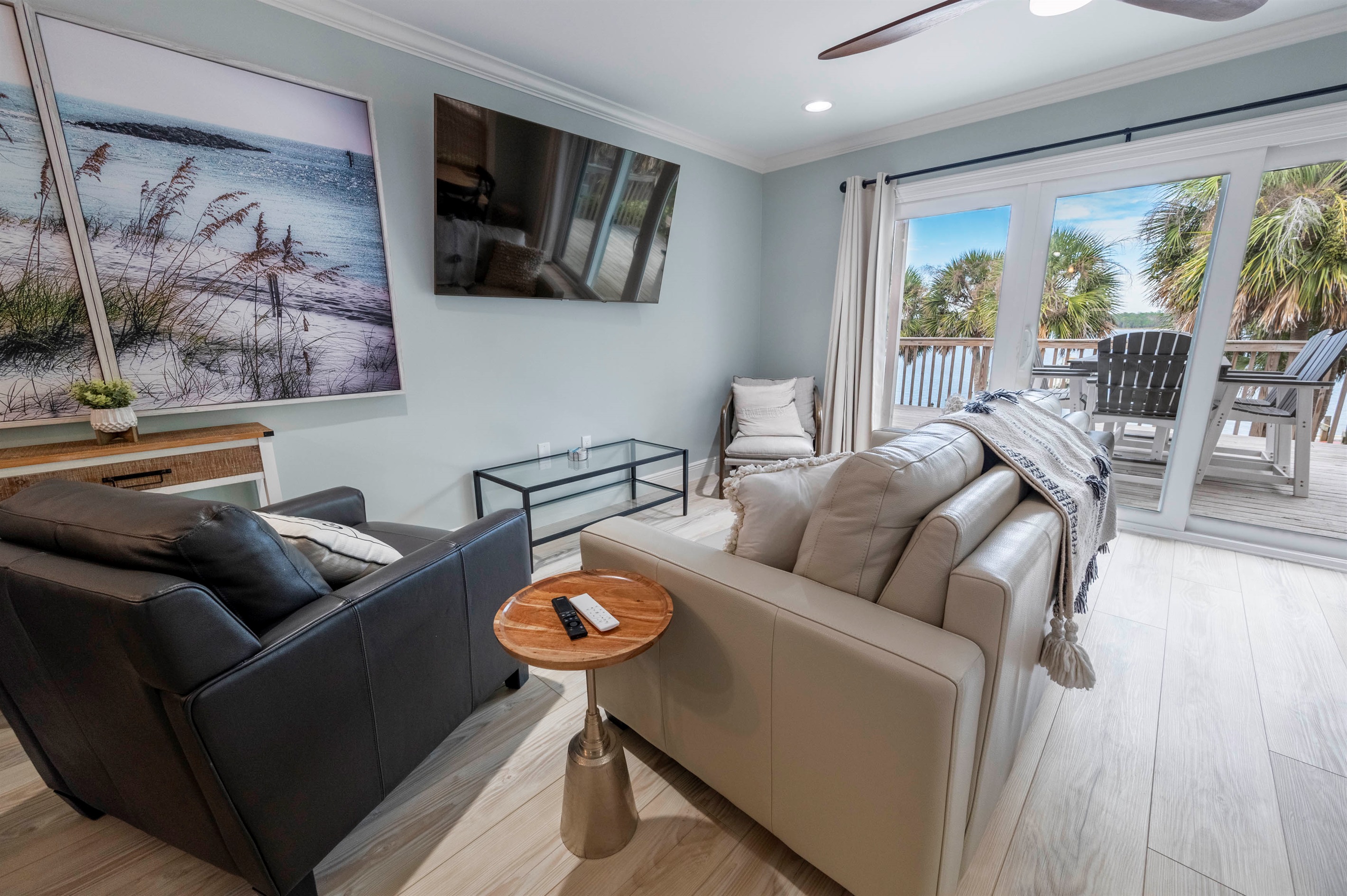 Relax in a modern beachside living room with cozy decor and balcony views at “Gone Coastal,” Laguna Bella, Gulf Shores, AL.
