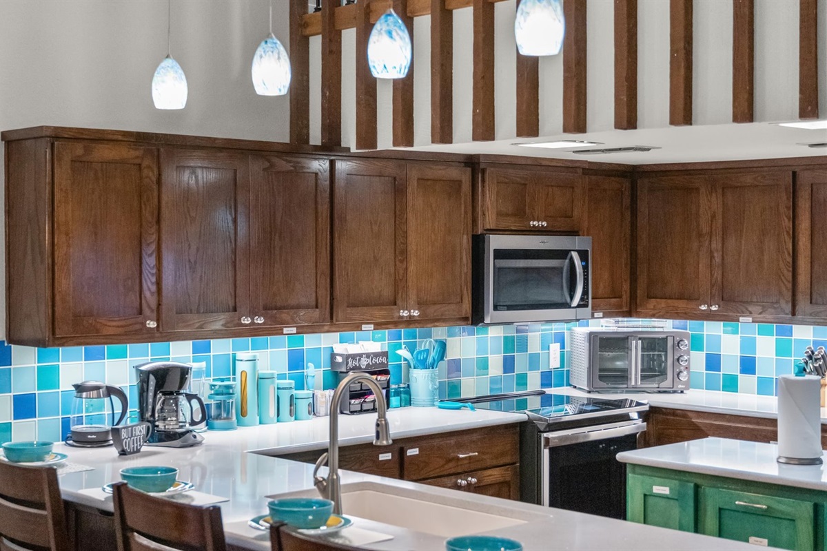 The kitchen is compact yet efficient, with a built-in trash can, island storage, and cabinets full of dishes and tools for all your needs. Thoughtfully designed to maximize space.