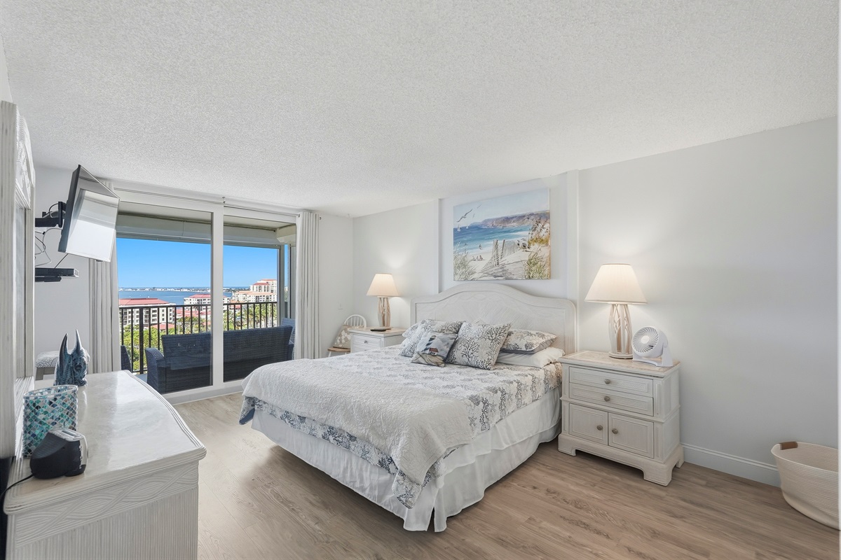 The master bedroom features a king-sized bed and a calming atmosphere, perfect for relaxing after a day at the beach or exploring the city. It offers stunning Boca Ciega Bay views with sunrise and sunset, abundant natural light, and a private en-suite bath