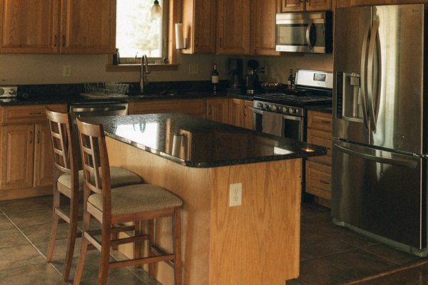 Kitchen with island and 2 barstools