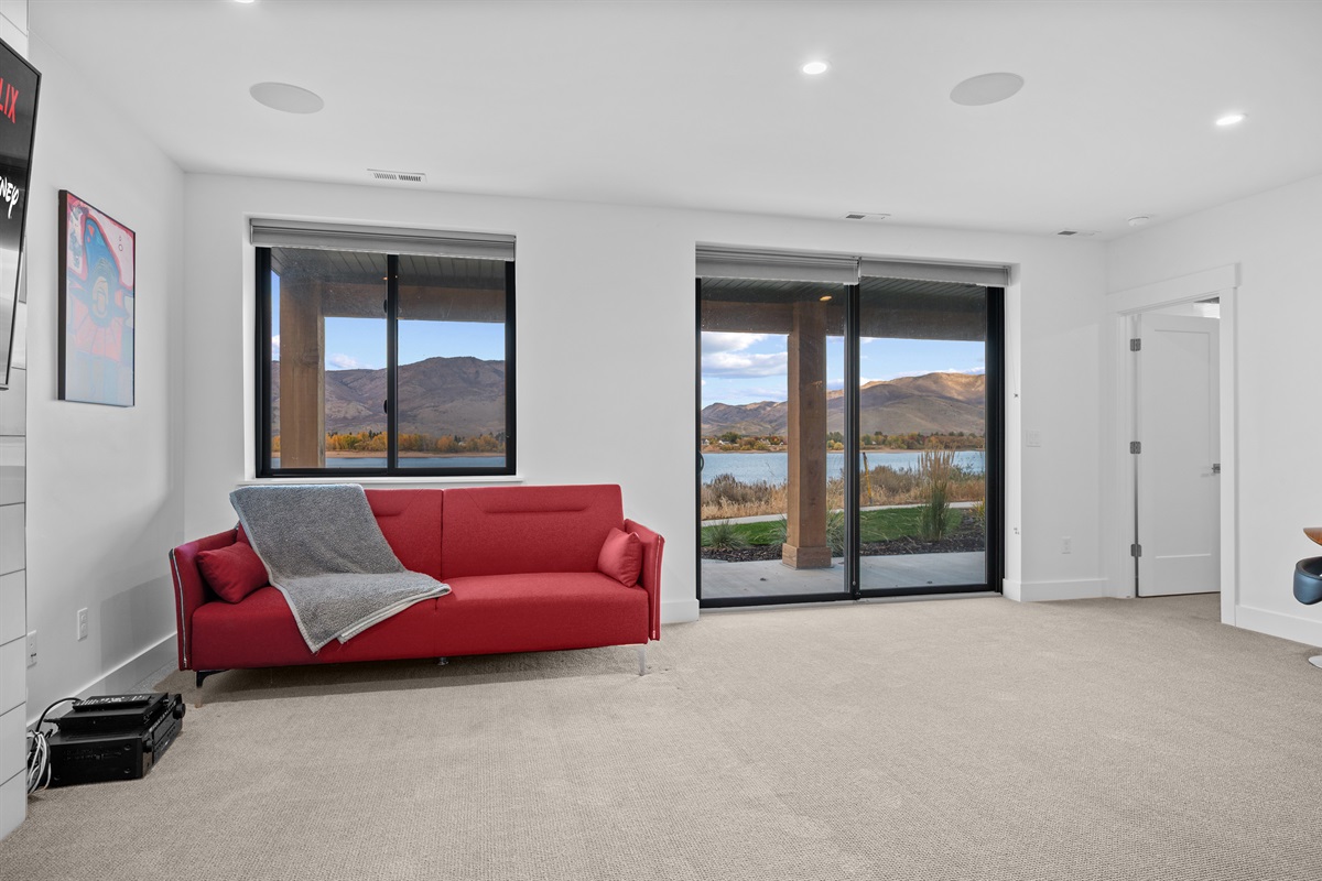 Lower-level living room with lake views and walk-out patio access to Pineview Reservoir.