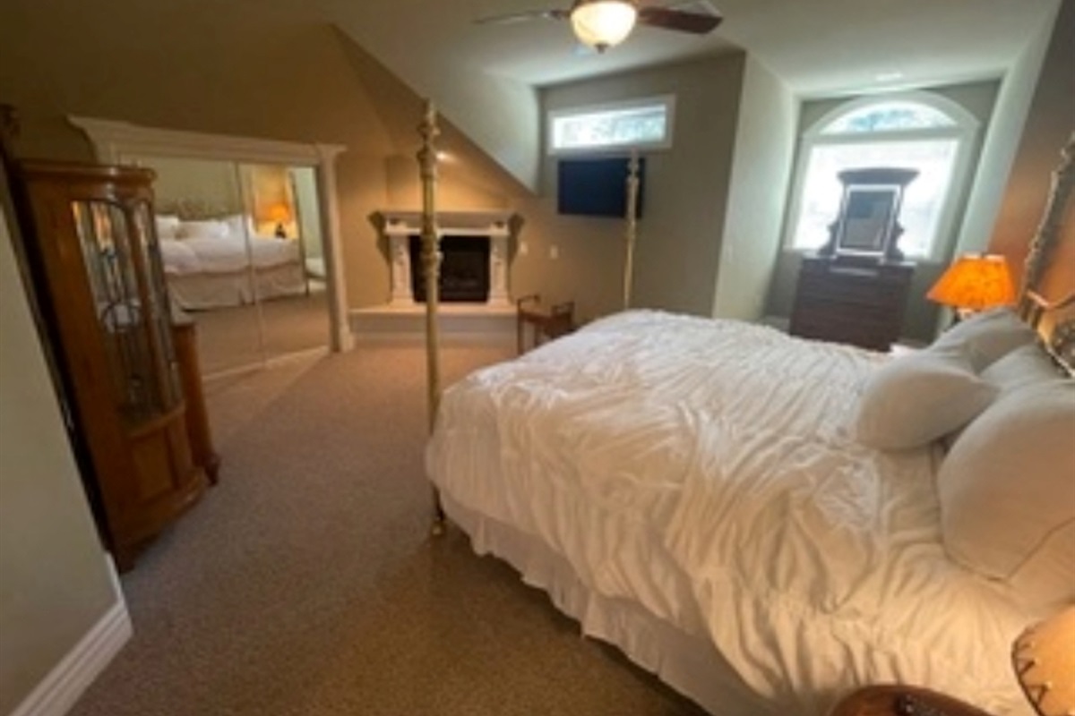 Bedroom #2 with king bed, gas fireplace, and TV.