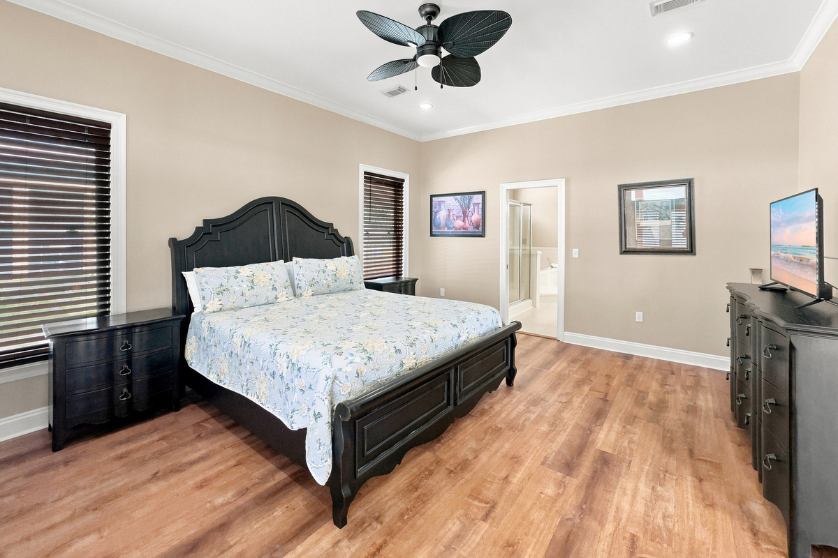 Comfortable bedroom with ceiling fan and coastal styling