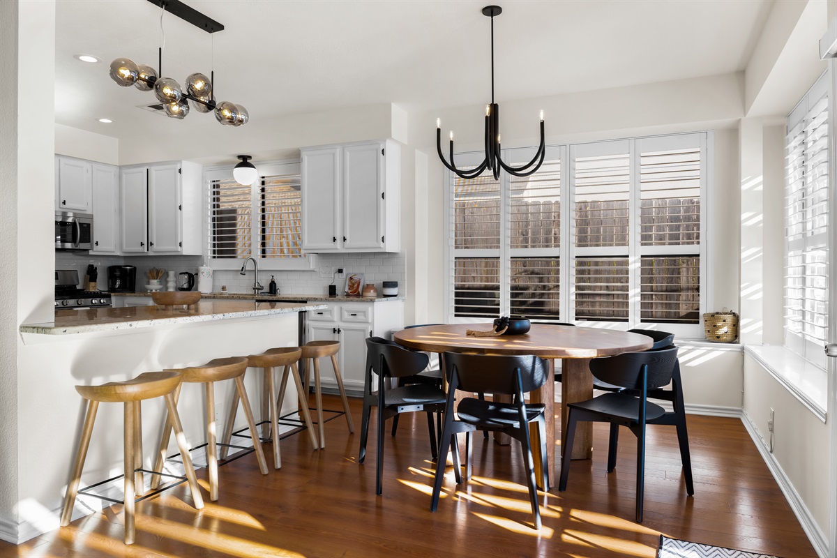 Modern kitchen with a circular dining table and a stylish bar seating area.