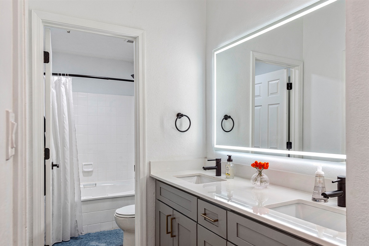 Modern and clean bathroom featuring a stylish mirror and all essential amenities for a comfortable stay.
