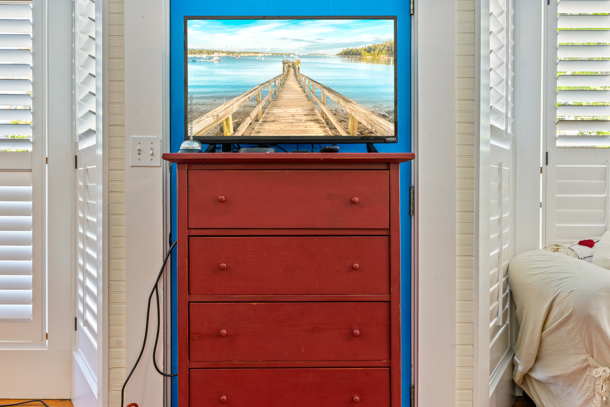 The private theater station inside the "Crew’s Quarters." Positioned on a classic red dresser, this Roku Smart TV provides the little sailors with their own dedicated entertainment zone to stream movies and wind down after a day on the coast.