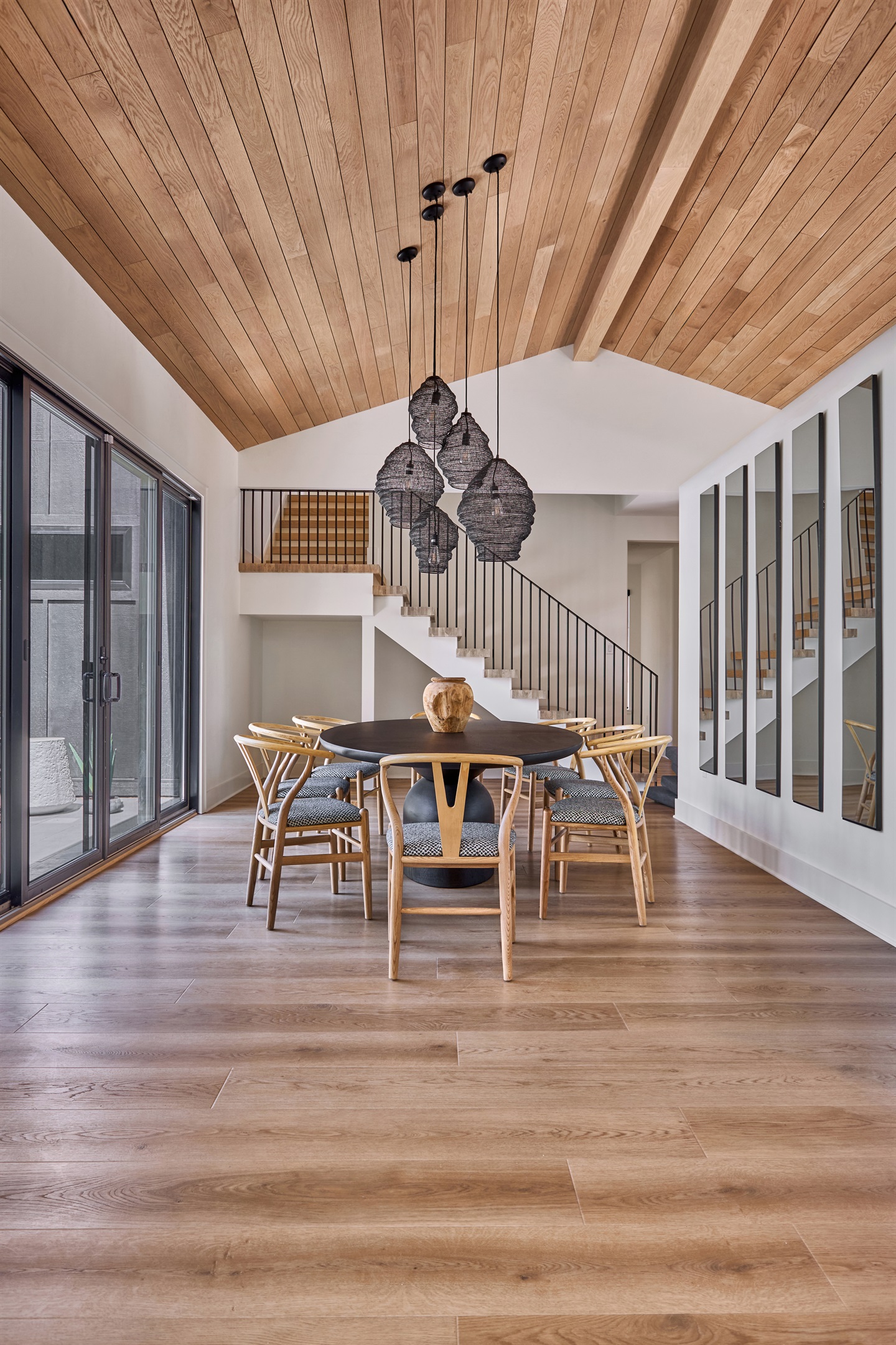 Gather around in this stunning dining space featuring vaulted wood ceilings, modern pendant lighting, and seating for eight, perfect for family meals or evening conversations.