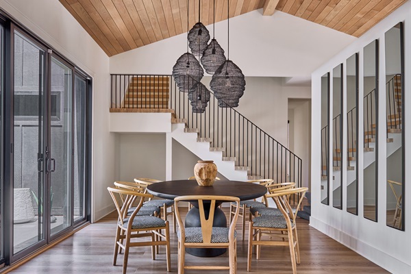 Gather around in this stunning dining space featuring vaulted wood ceilings, modern pendant lighting, and seating for eight, perfect for family meals or evening conversations.