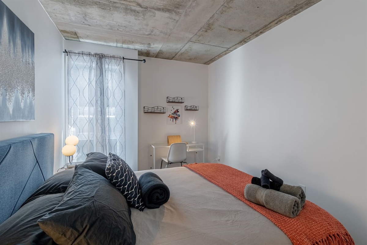 Chambre avec un lit Queen confortable et un bureau de travail.
