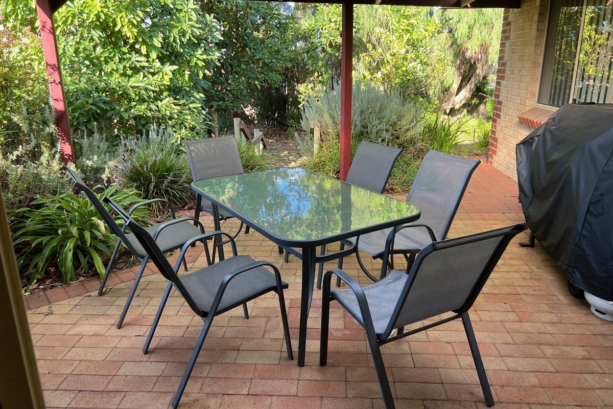 Outdoor dining with large BBQ,  leads down to the lawned area