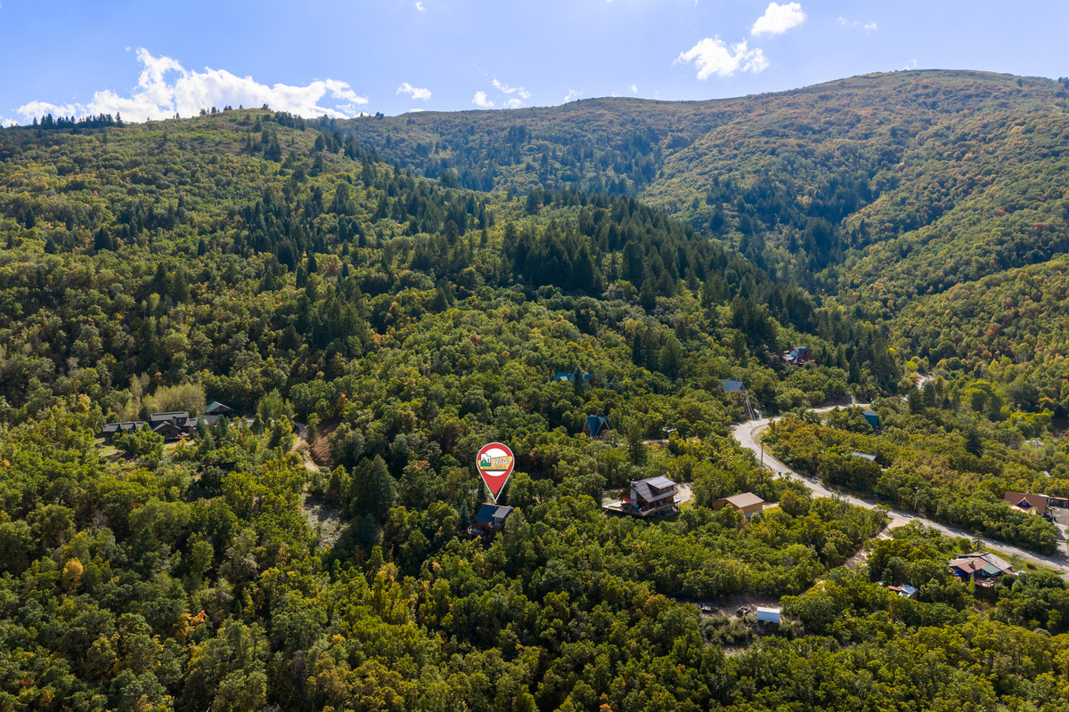Wide aerial view showing the secluded neighborhood surrounded by rolling mountain terrain.