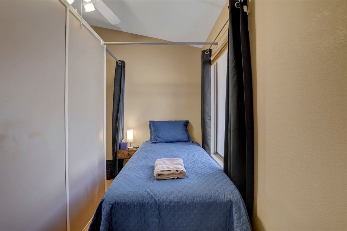 Cozy curtained twin nook with lamp, fan & fresh linens