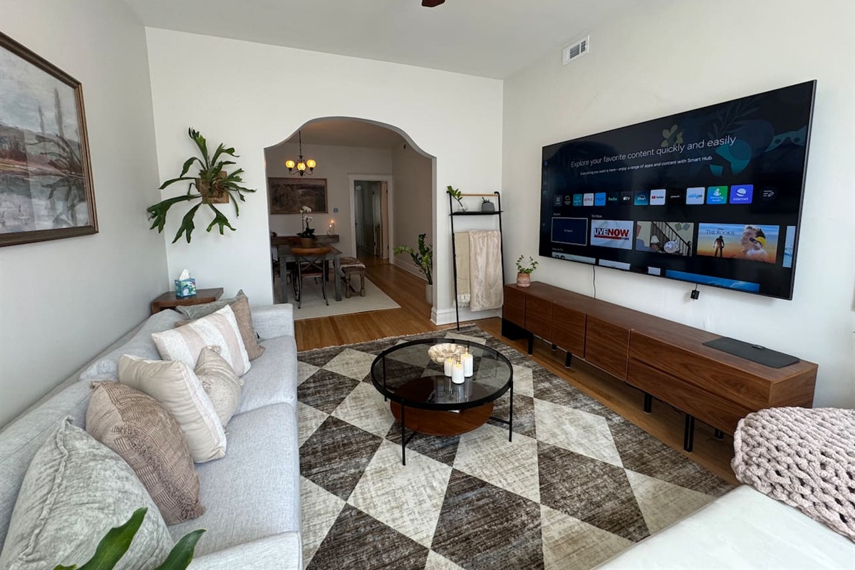 Spacious living room with smart TV, comfortable seating, and stylish decor for rlaxing after exploring Chicago.