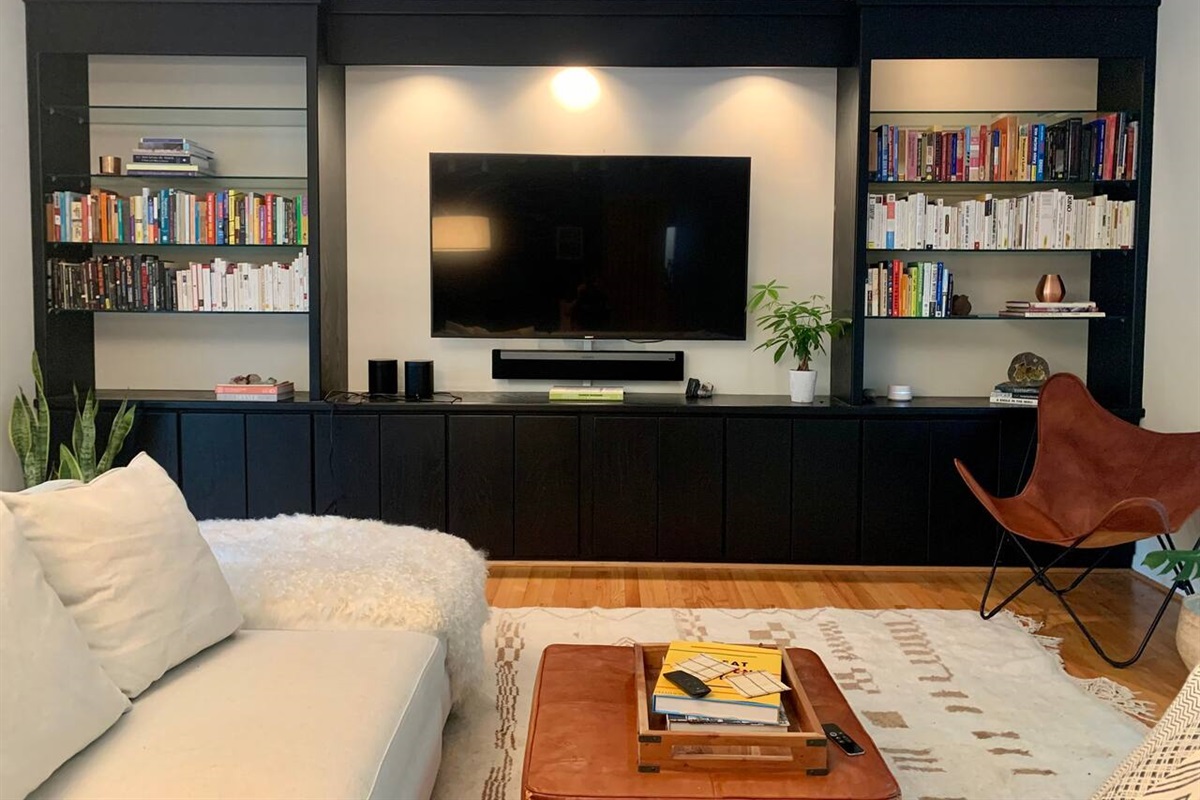 The living room is anointed with the owner's personal book collection, a 65" Sony TV, Apple TV, and Sonos surround. Room & Board sectional, handwoven rugs from Morocco, leather goods from The Citizenry, and live plants tie this room together.