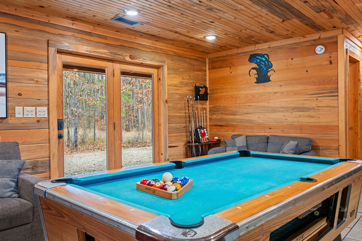 Set against rustic wood walls, the pool table creates an easy spot for friendly competition and relaxed evening entertainment.