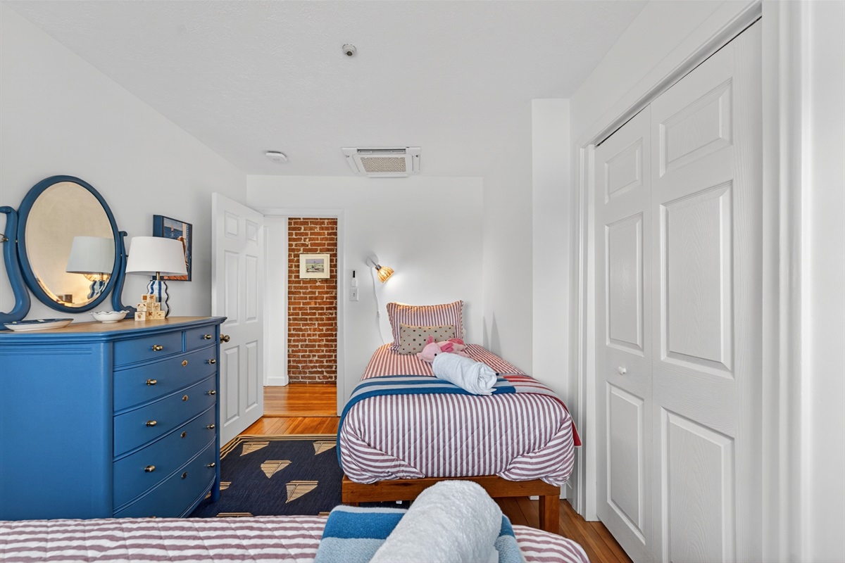 Cheerful twin bedroom with two beds and cozy coastal touches, ideal for kids or extra guests.