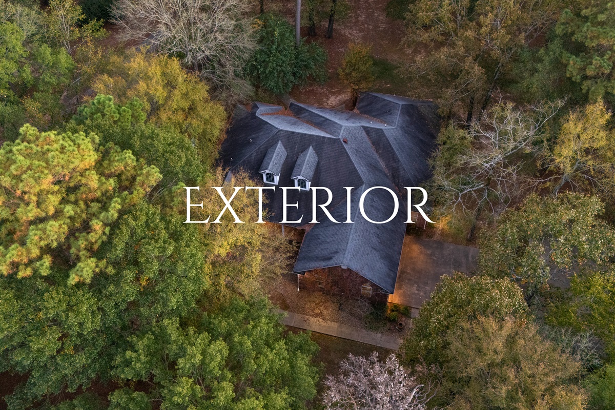 Aerial exterior showcasing the secluded wooded property.