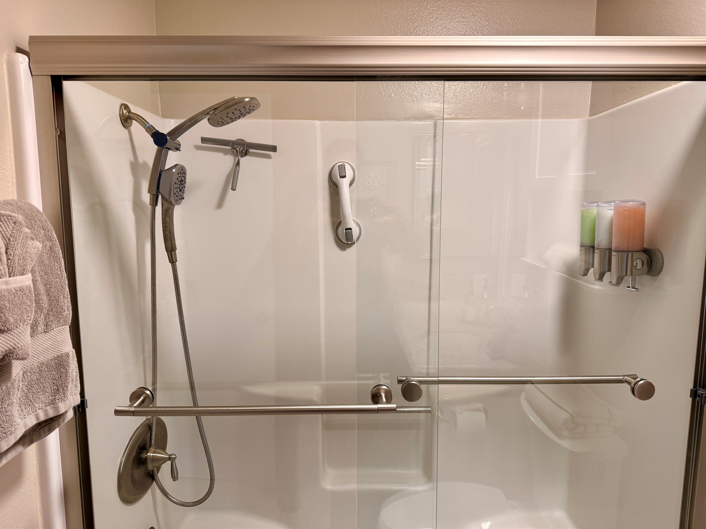 Hall bathroom tub shower combo. Soap dispenser has shampoo, conditioner, and body wash.