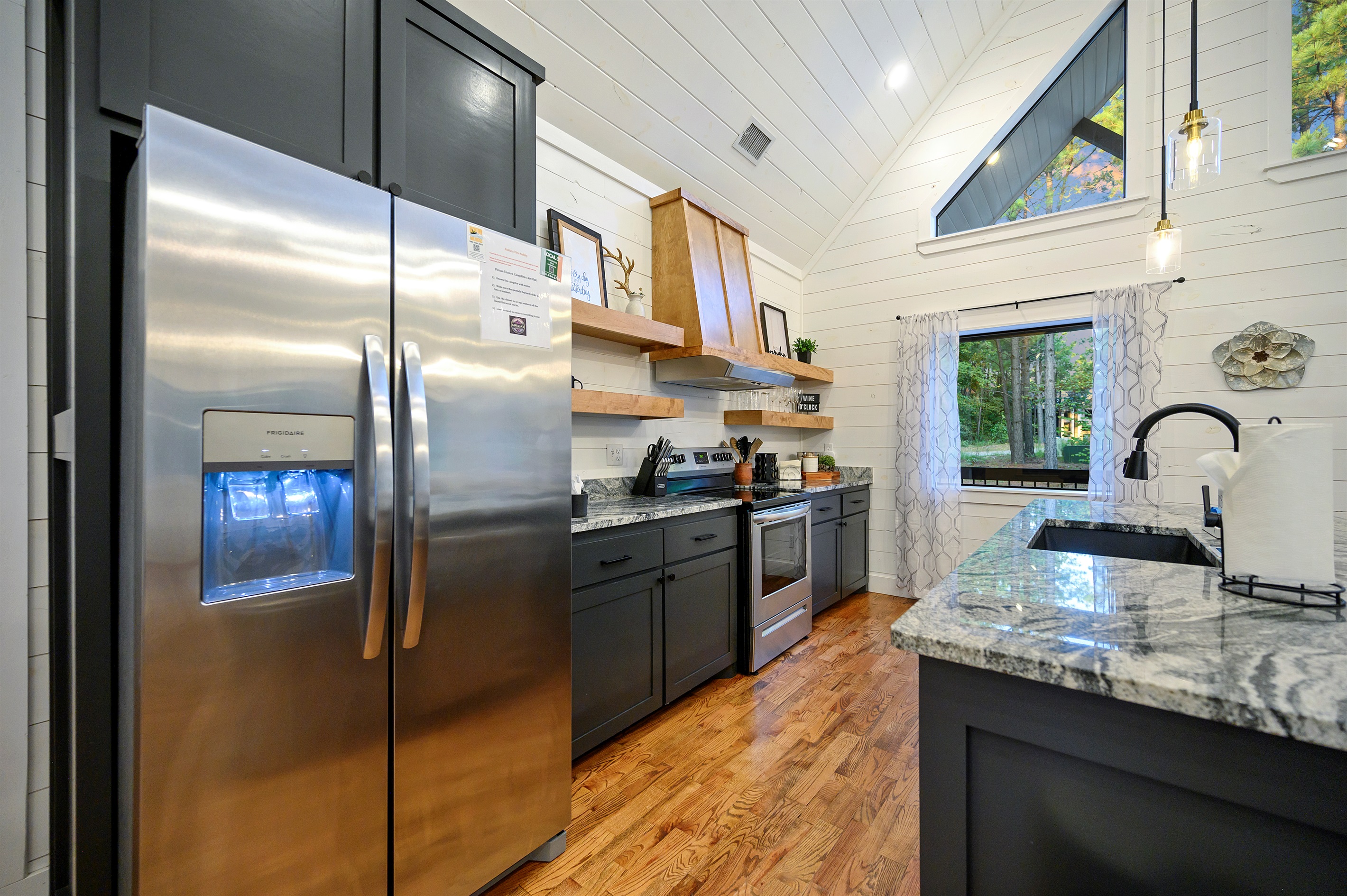 Another angle of your stylish kitchen—showcasing sleek appliances, rustic open shelving, and your stunning marble countertop!