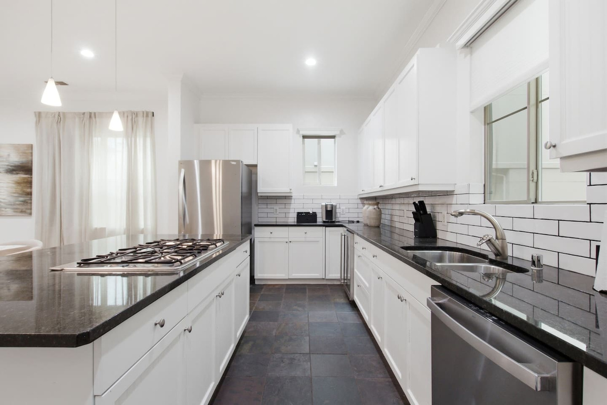 Gas cooktop with stainless range hood and full oven below. Fully outfitted with cookware and utensils for guests who want to cook in and skip the restaurant tab for a night.
