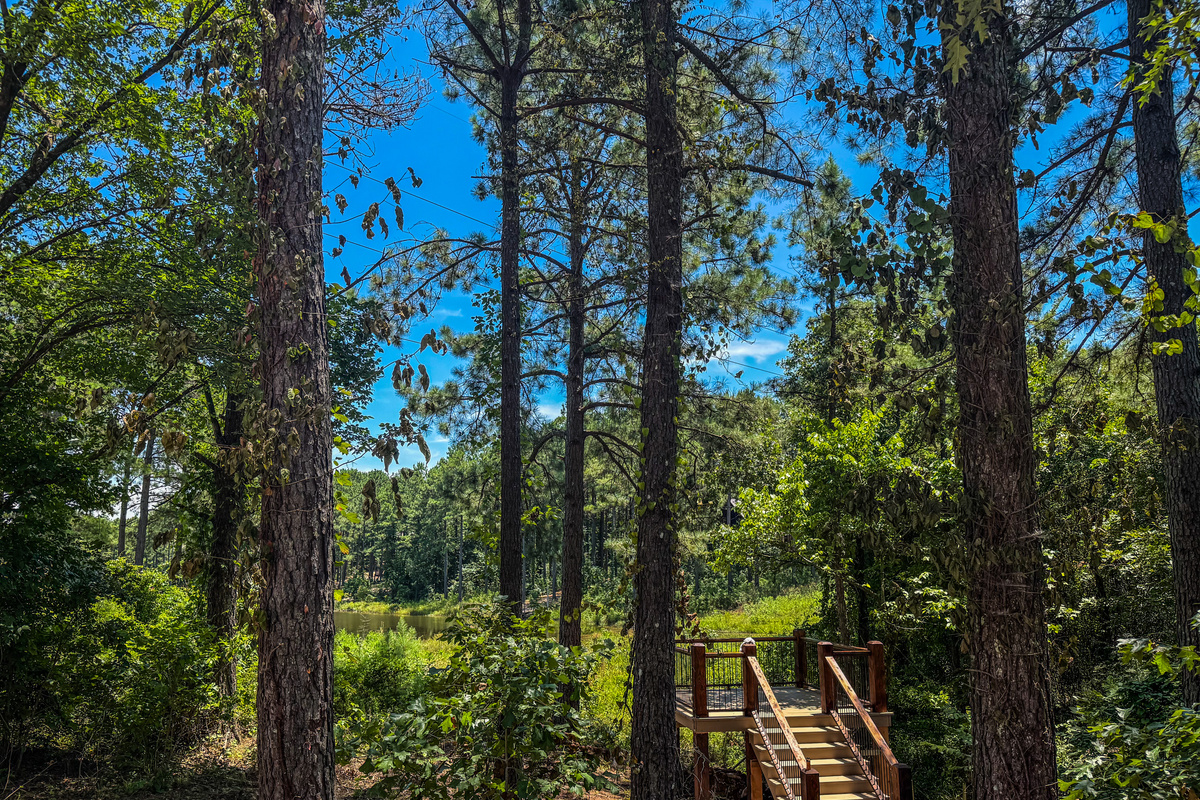 Relax on a private overlook with Adirondack chairs and peaceful views of the pond framed by towering pines.