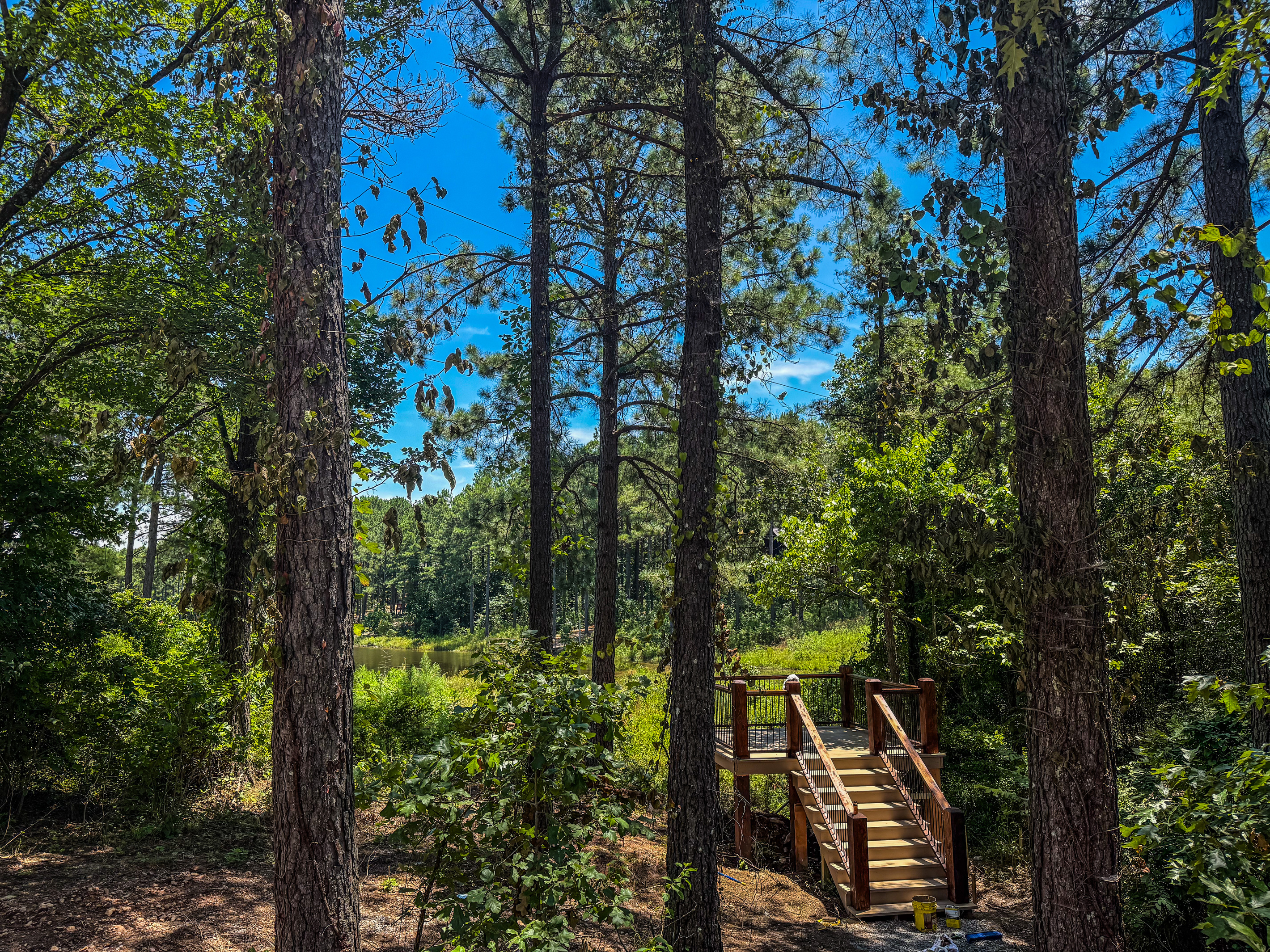 Relax on a private overlook with Adirondack chairs and peaceful views of the pond framed by towering pines.