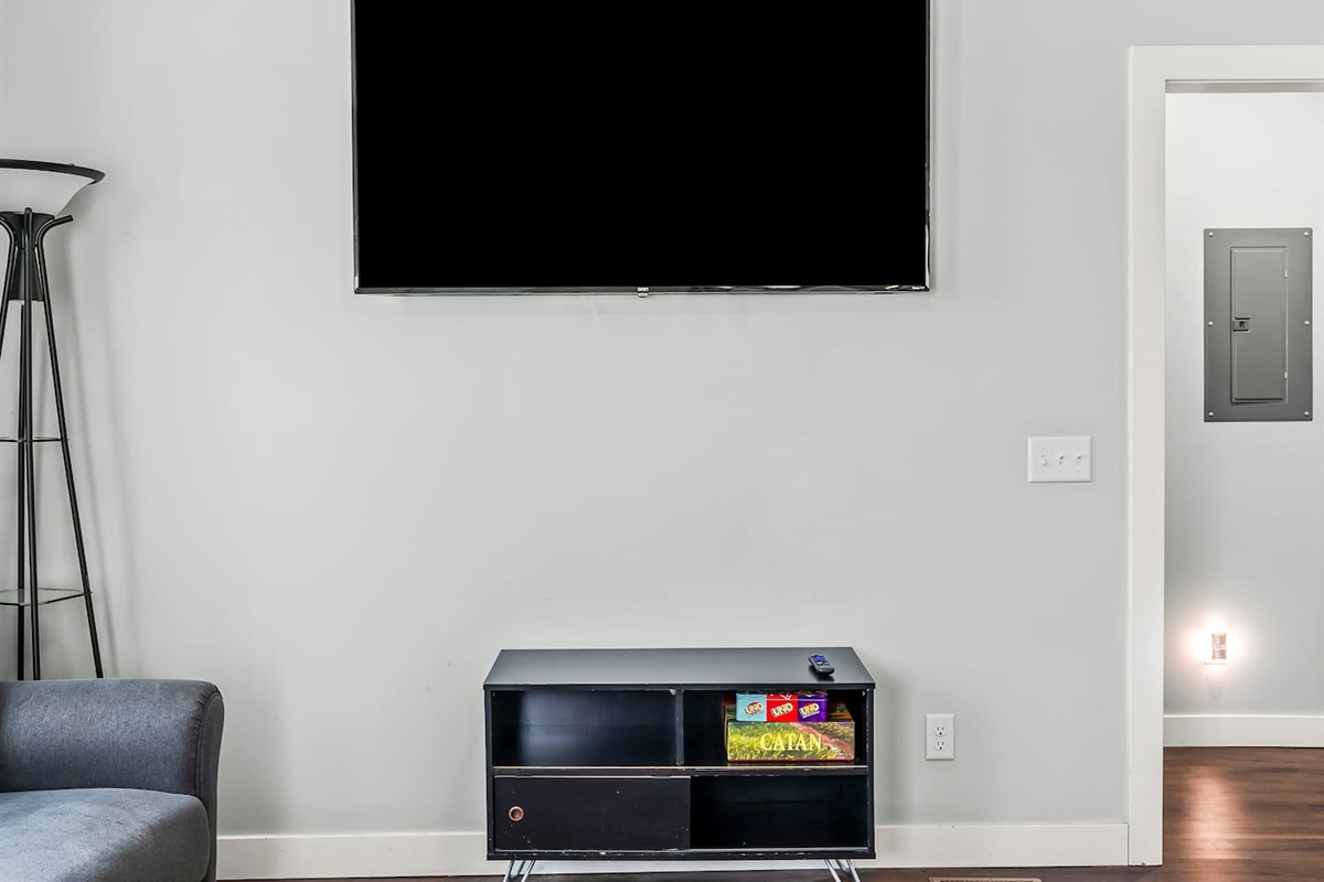 Entertainment-ready living room with a large TV, board games, and a cozy setup for streaming or game nights.