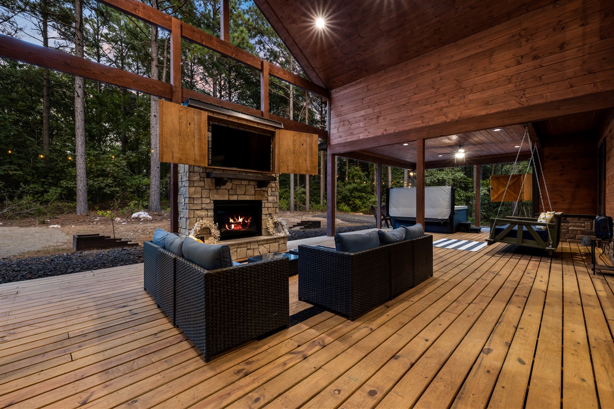 Spacious outdoor patio featuring comfortable seating, a cozy fireplace, and TV—perfect for relaxing, dining, and entertainment outdoors.
