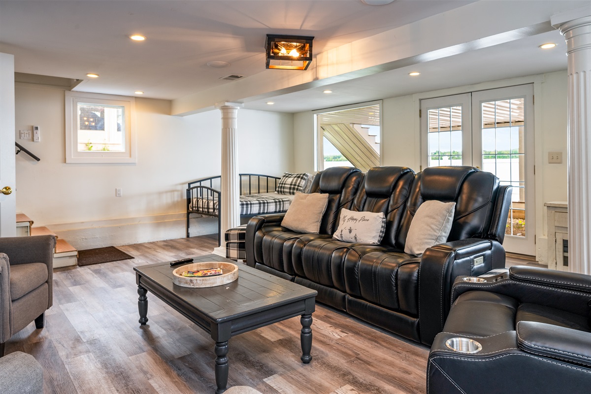 Spacious lower-level lounge with plush reclining seats, a game area, and access to the patio for easy indoor-outdoor living 🎮🛋️🚪