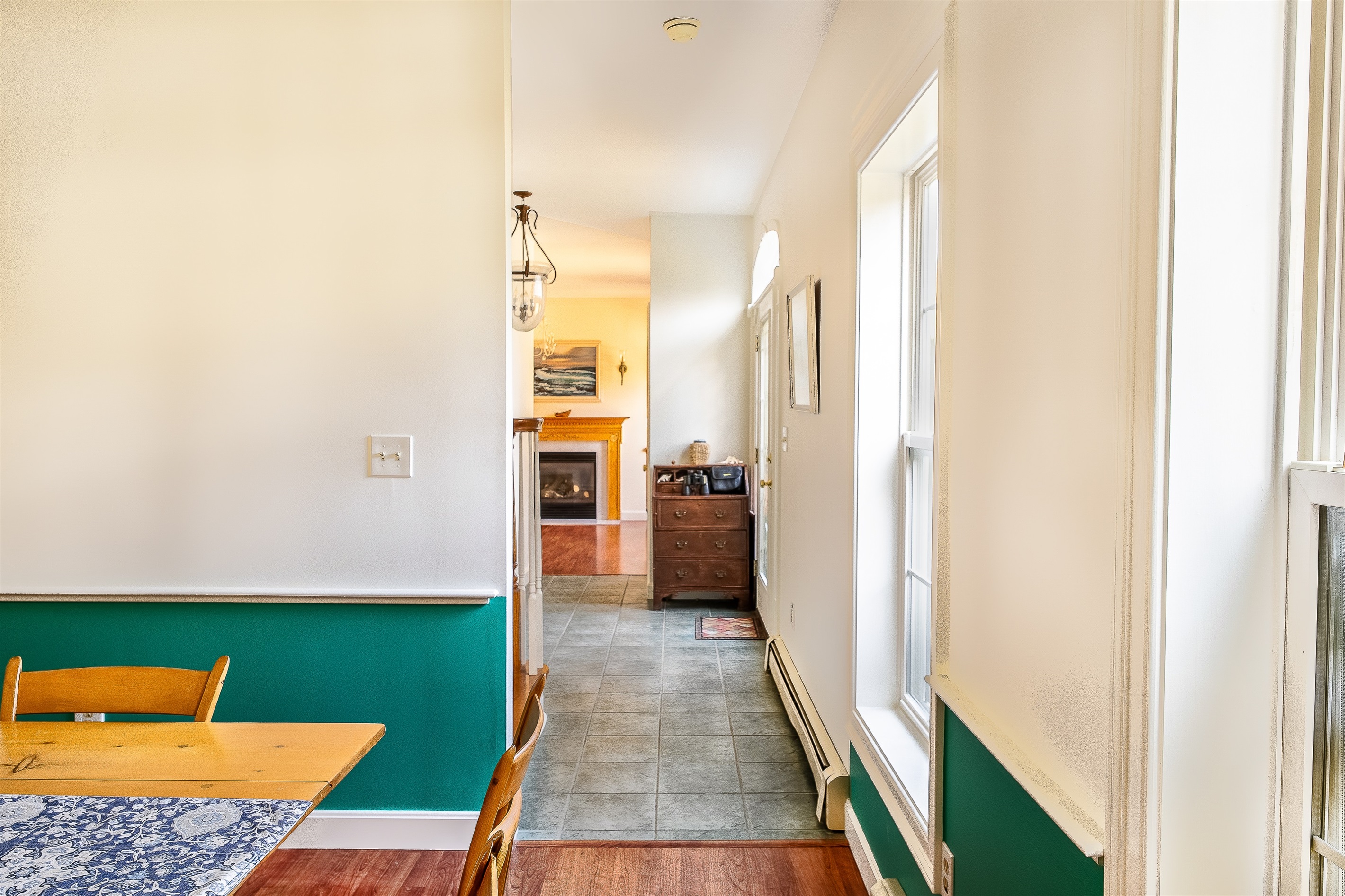 This perspective from the formal dining room shows the home's impressive scale, looking back through the foyer toward the cozy den. The expansive main level ensures your group has plenty of room to spread out and relax after exploring Southwest Harbor.