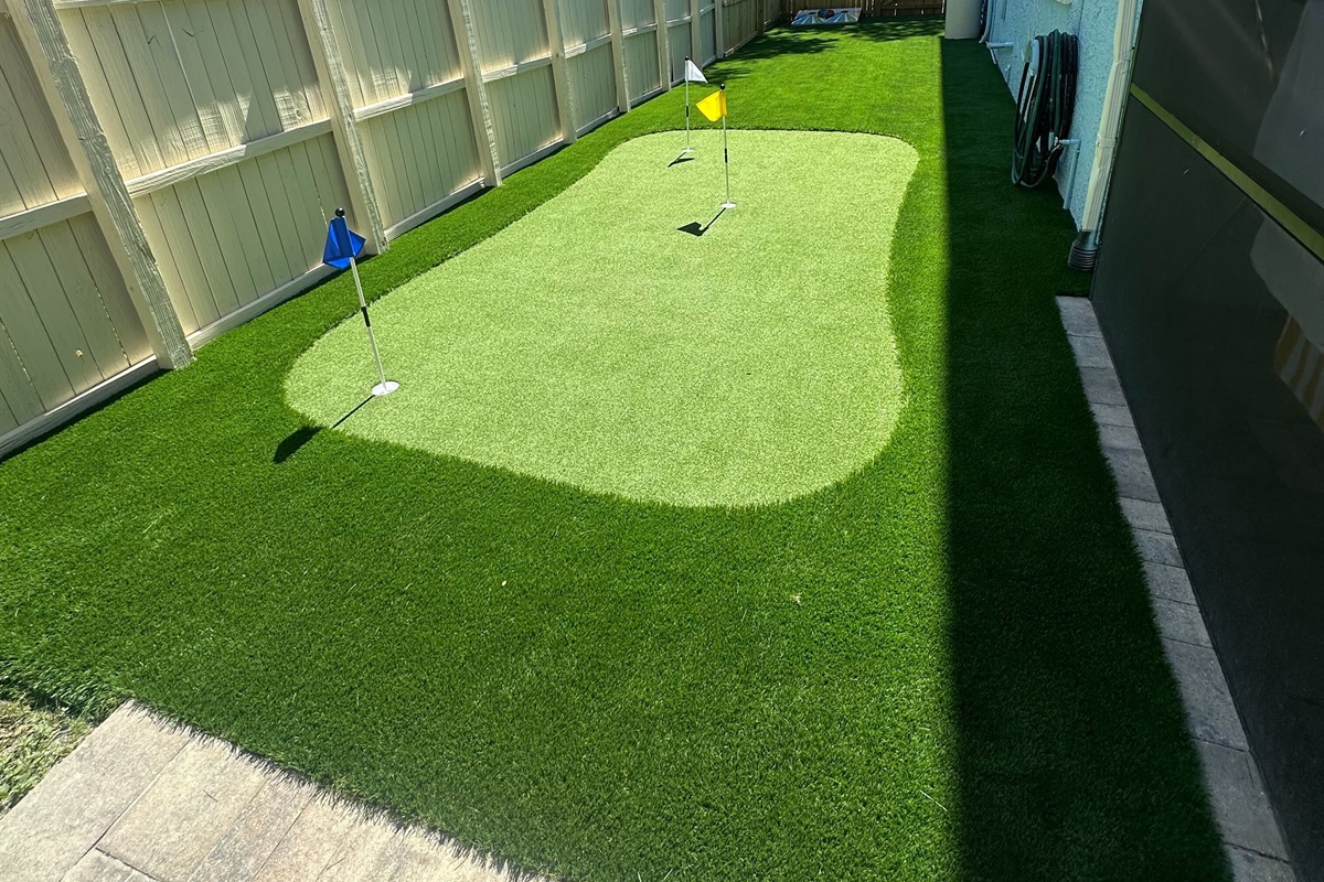 Step outside and discover your own private play zone! This fenced-in backyard features a vibrant cornhole set and a professionally installed putting green—perfect for friendly competition, family fun, or a relaxing solo round of practice.