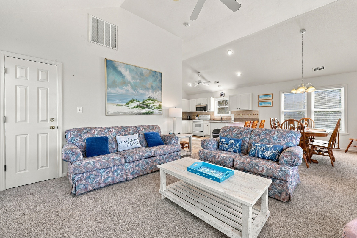 Two sofas, big coastal art and an open layout that keeps everyone together.
