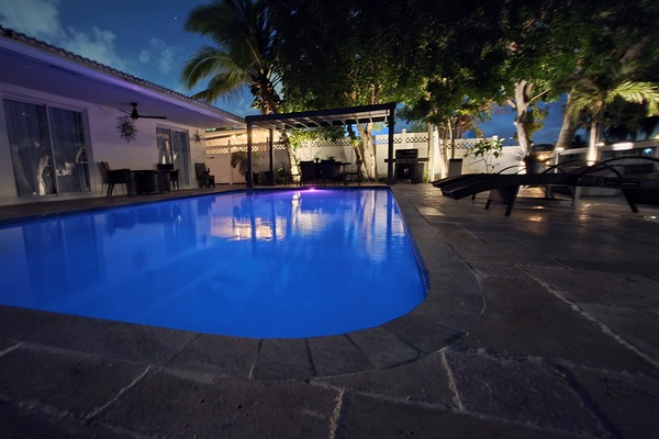 Resort-style heated pool with ambient evening lighting