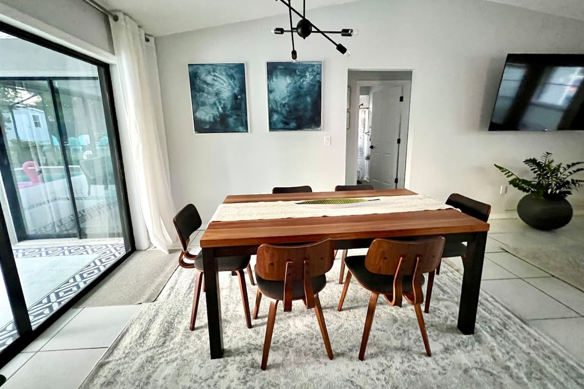 Dining table conveniently located near the kitchen and at an angle where the large Roku tv can also be watched 