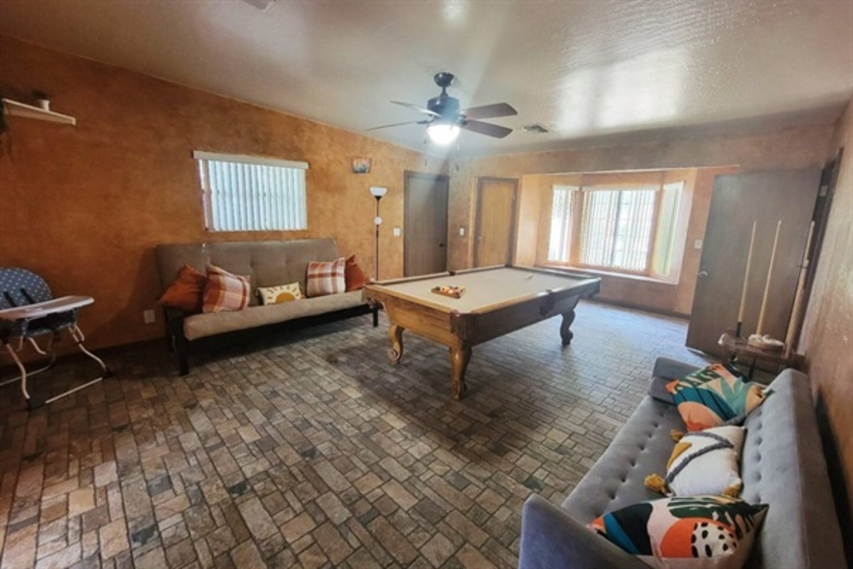 This vibrant game room features a full-size pool table, cozy lounge seating, and warm Southwestern charm for hours of laid-back entertainment.