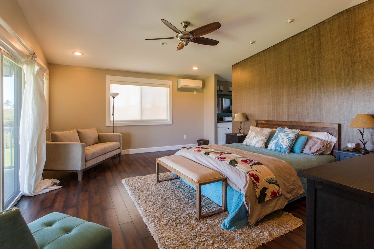 Primary bedroom with seating area-- Cal King Bed, doors that open out to the wrap around lanai and TV.