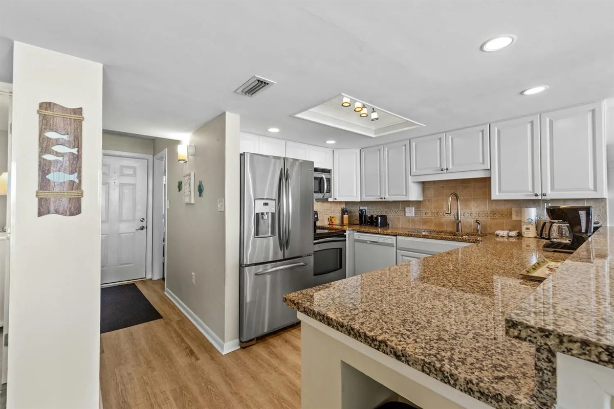 Well appointed kitchen with granite counter tops and full size appliances