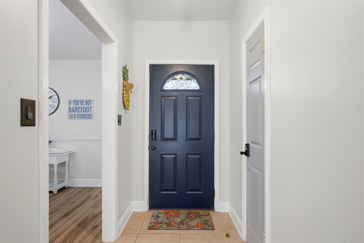The welcoming entryway features a charming blue front door and a bright, open layout that leads into the main living areas of the home. With easy access to nearby rooms and plenty of natural light, which creates a warm and inviting first look for guests.