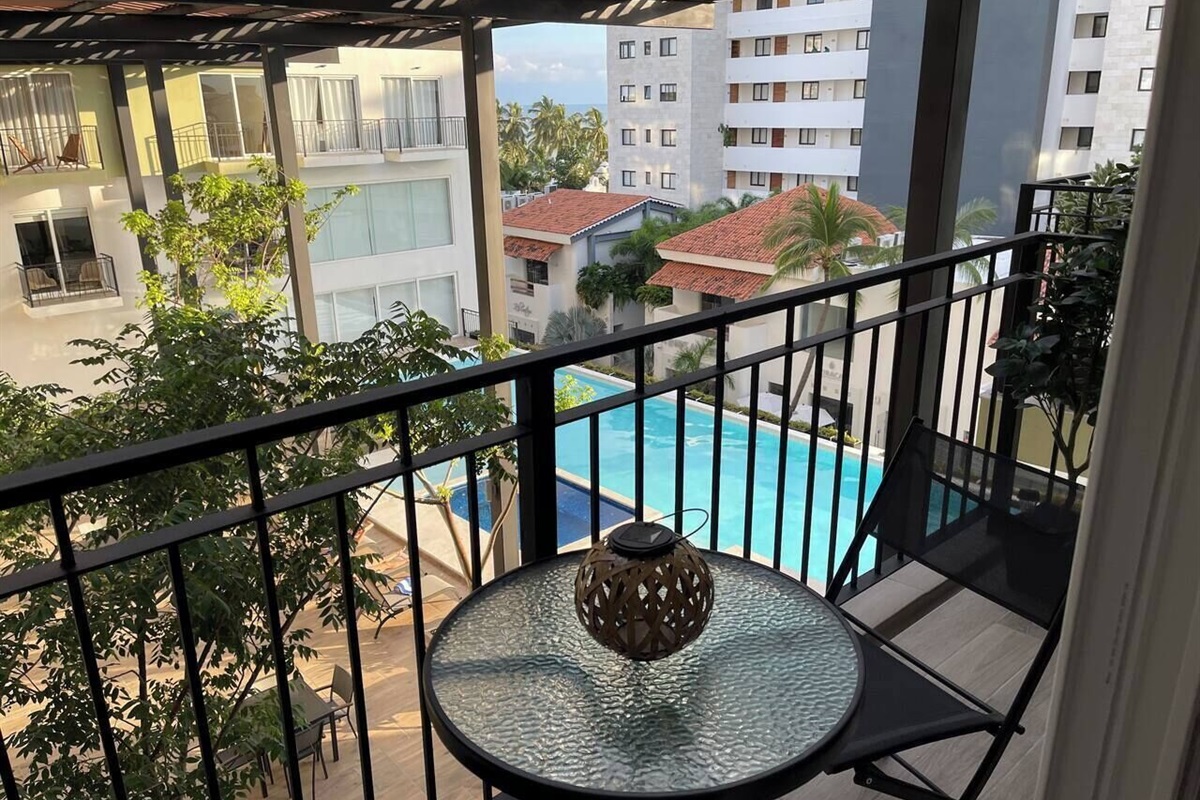 Small balcony overlooking the pool and a peek a boo of the ocean. small table and 2 chairs 320