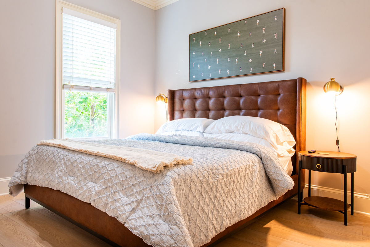 A third bedroom with a king bed and stylish leather headboard.