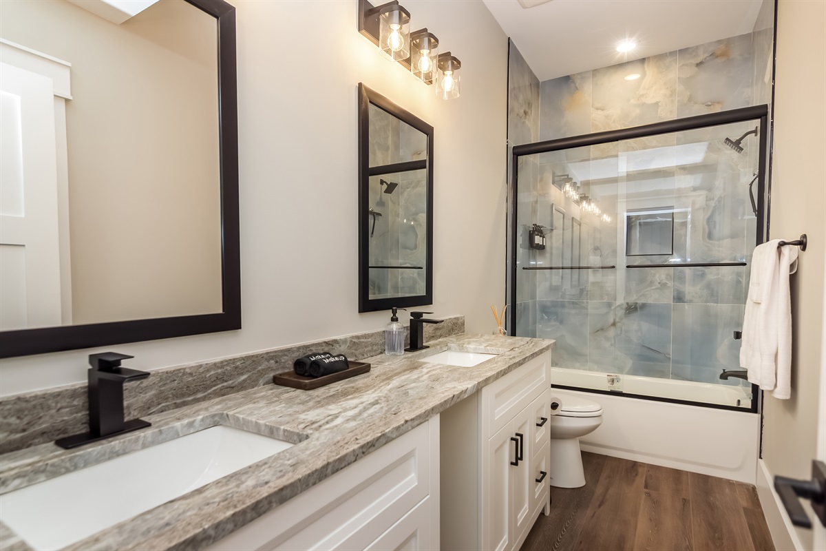 Full bathroom w/ dual sinks and tile shower