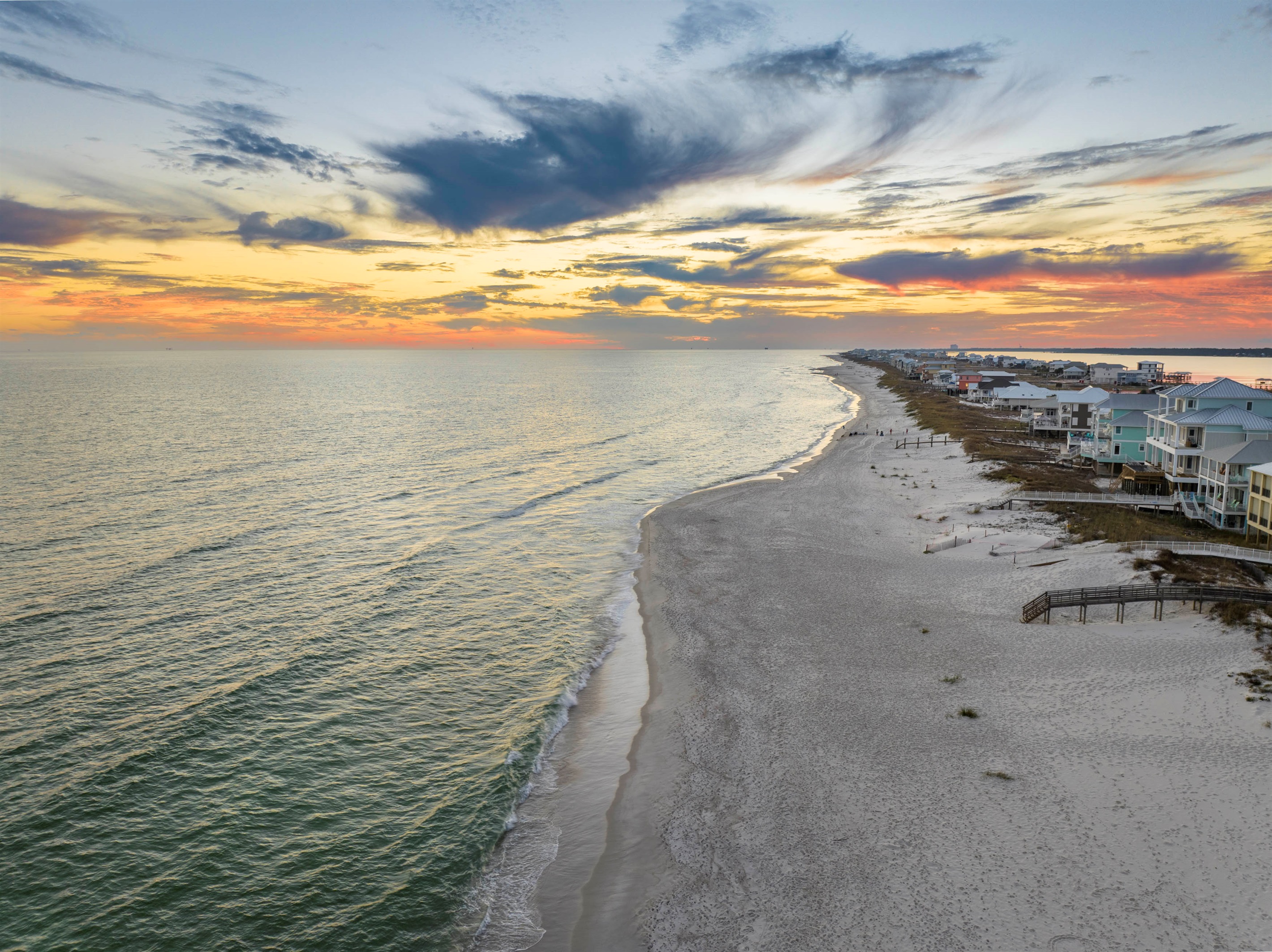 Peaceful beachside sunset with vibrant skies and tranquil coastal charm in Gulf Shores, AL.
