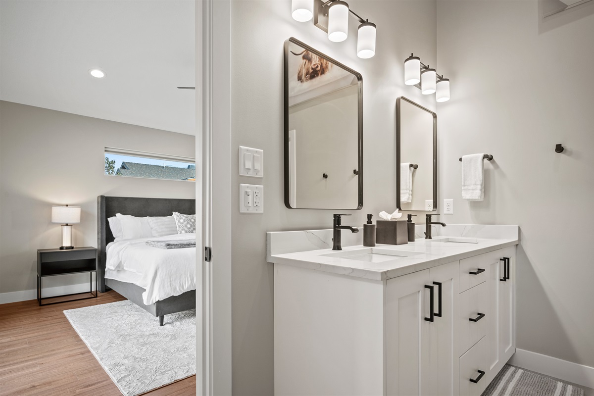 Spacious ensuite features dual sinks, twin mirrors, and large cabinet, plus complimentary essentials.