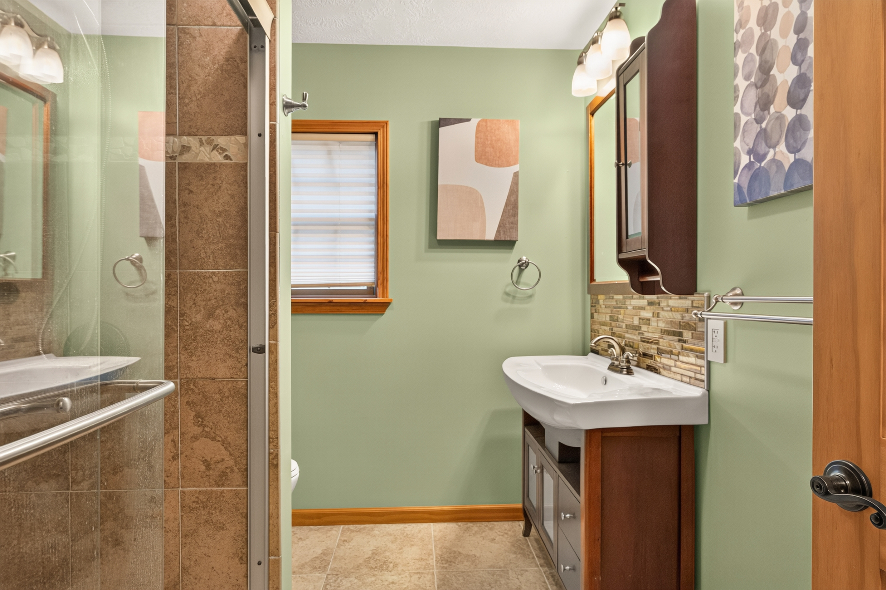 Shared bathroom with tiled shower and vanity
