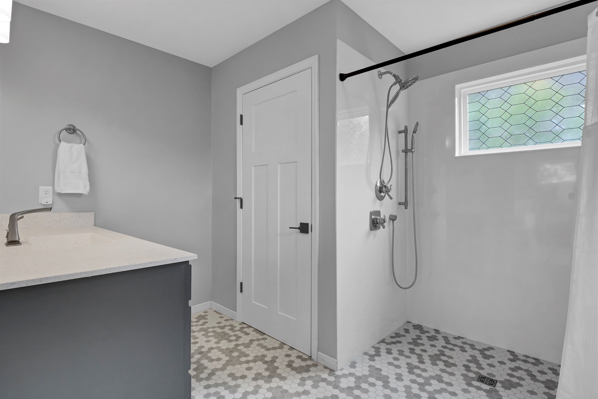 Bright and spacious wheelchair-accessible bathroom designed for comfort and ease featuring a sleek, modern roll-in shower