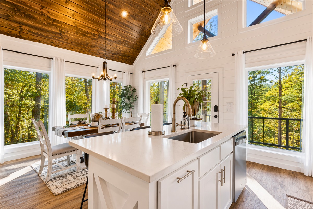 Surrounded by towering windows and warm wood accents, the kitchen island is the perfect place for slow mornings and evening conversations.