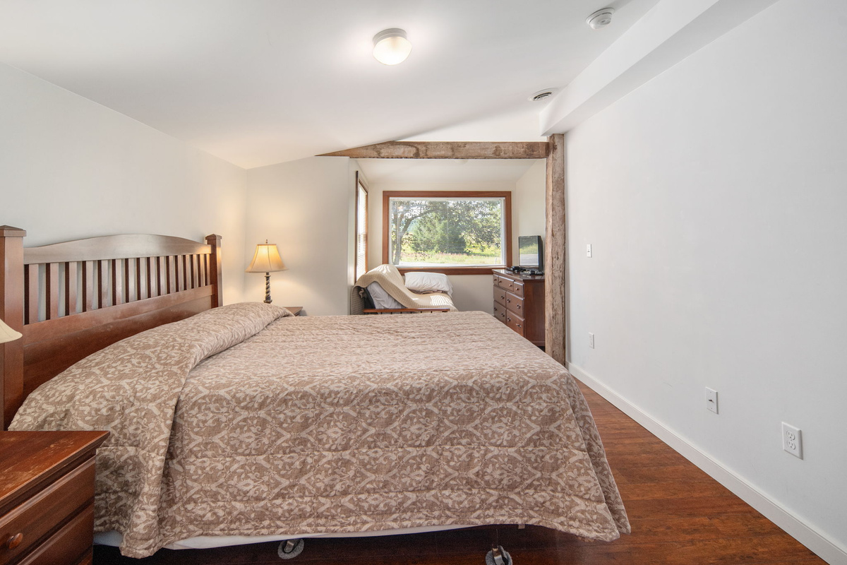 Warm wood details and leafy views create a restful bedroom setting.