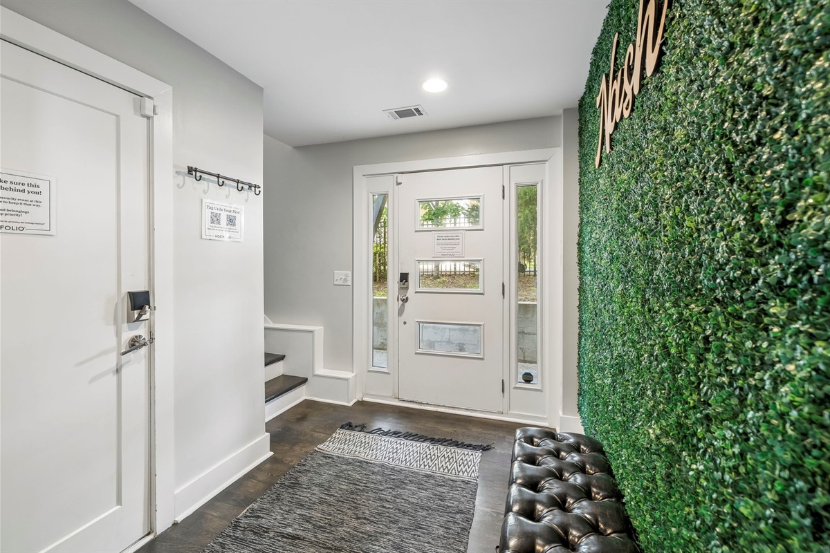 Eye catching artificial green wall brings a vibrant pop of nature inspired style indoors - Paired with a tufted leather bench for a cozy spot to sit, drop bags, or snap a photo - Perfect Instagram worthy moment that adds flair to the hallway or entryway